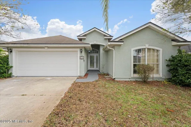 a view of a house with a yard and garage