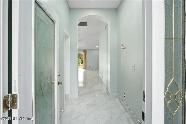 a view of a kitchen with kitchen island a sink a counter space and stainless steel appliances
