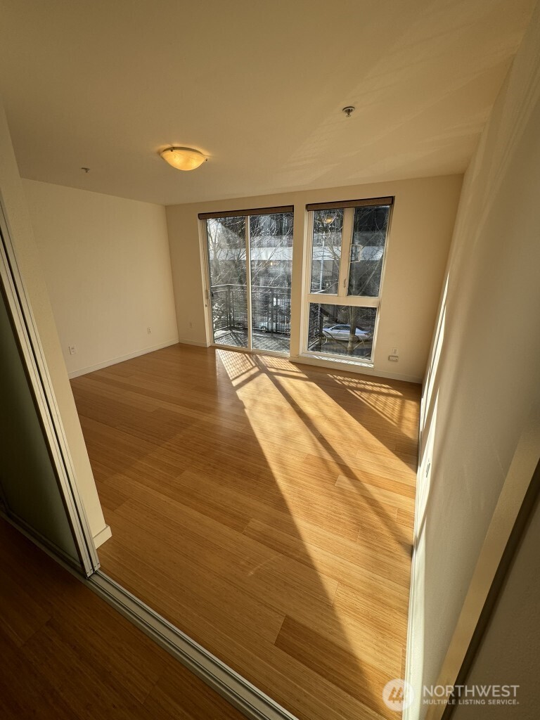 3104 Western Avenue, Unit 215 Seattle, WA 98121 - Photo 16 of 18 a view of an empty room with wooden floor and a window