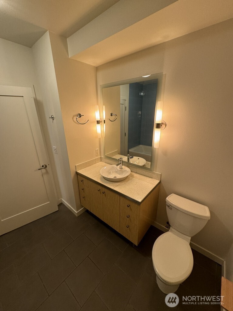 3104 Western Avenue, Unit 215 Seattle, WA 98121 - Photo 4 of 18 a bathroom with a toilet sink and mirror