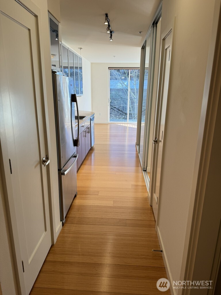 3104 Western Avenue, Unit 215 Seattle, WA 98121 - Photo 5 of 18 a view of a hallway with wooden floor and staircase
