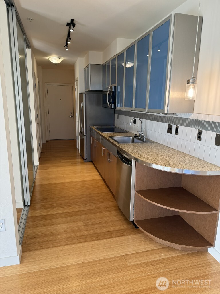 3104 Western Avenue, Unit 215 Seattle, WA 98121 - Photo 9 of 18 a kitchen with stainless steel appliances granite countertop a sink and cabinets