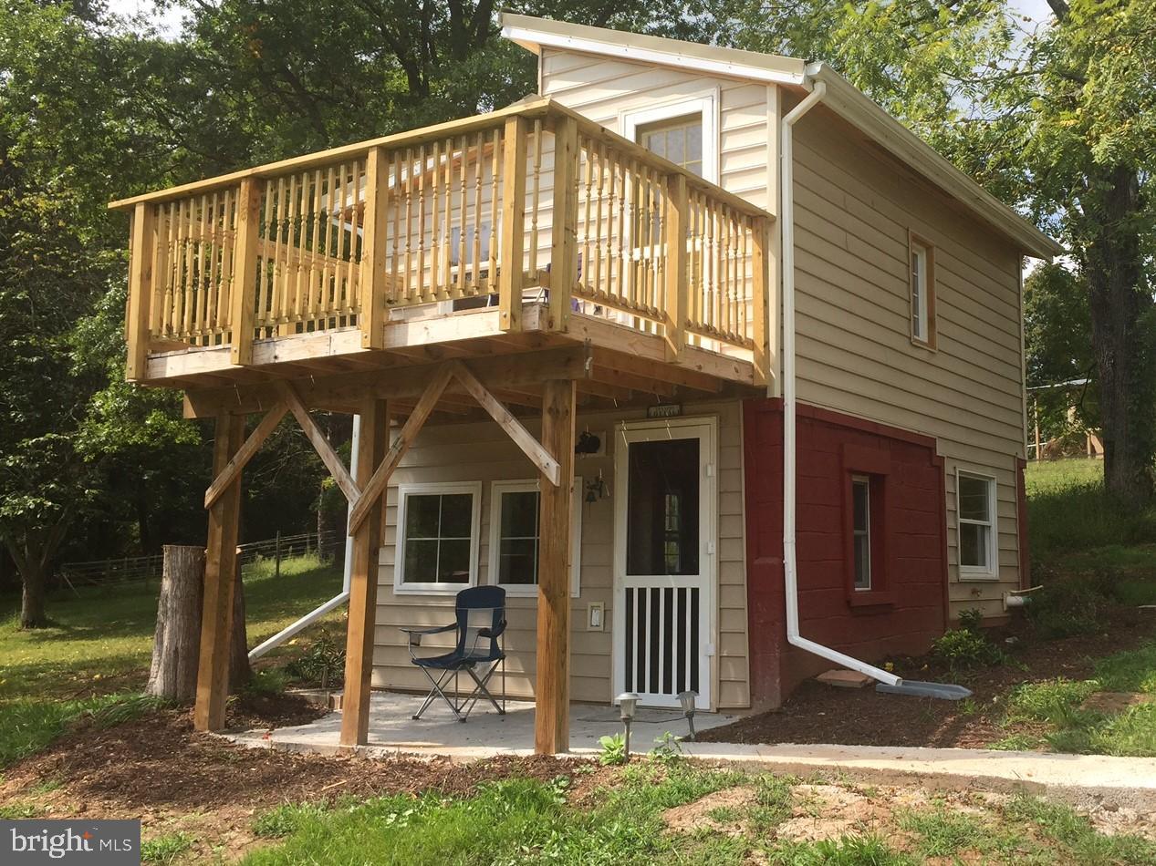 a view of a house with a yard balcony and a large tree