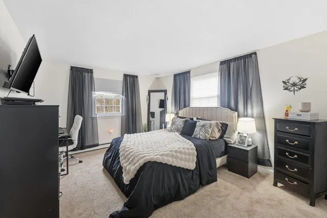 a bedroom with a large bed and a flat tv screen