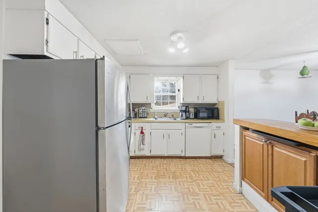 a kitchen with stainless steel appliances granite countertop a refrigerator sink and white cabinets