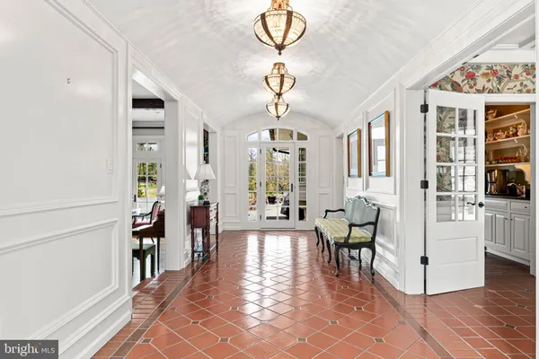 a large kitchen with stainless steel appliances kitchen island granite countertop a large stove a sink dishwasher and white cabinets with wooden floor