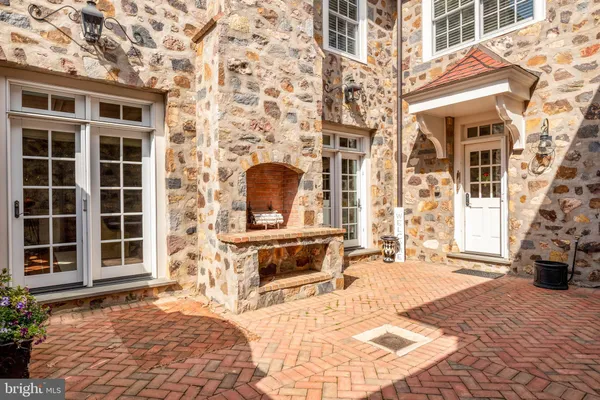 a kitchen with stainless steel appliances granite countertop a refrigerator a sink dishwasher a dining table and chairs with wooden floor