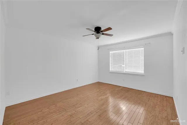 an empty room with a window and a ceiling fan
