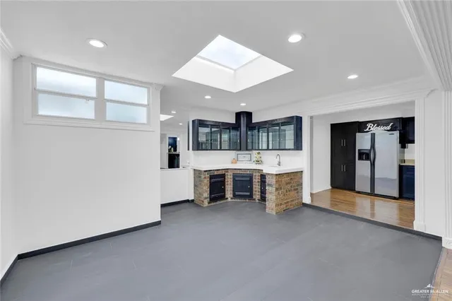a large room with kitchen view and a window