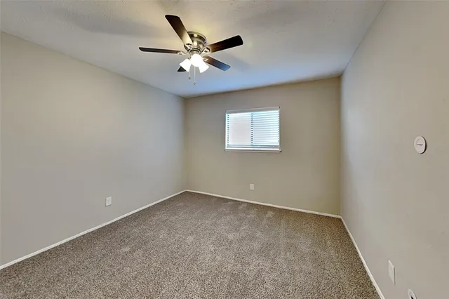 an empty room with closet and a ceiling fan