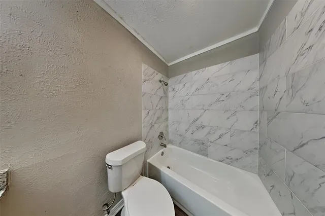 a bathroom with a granite countertop sink a toilet and a mirror