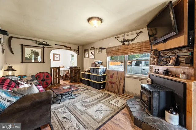 a living room with furniture a flat screen tv and kitchen view