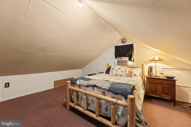 a bedroom with a bed next to a window