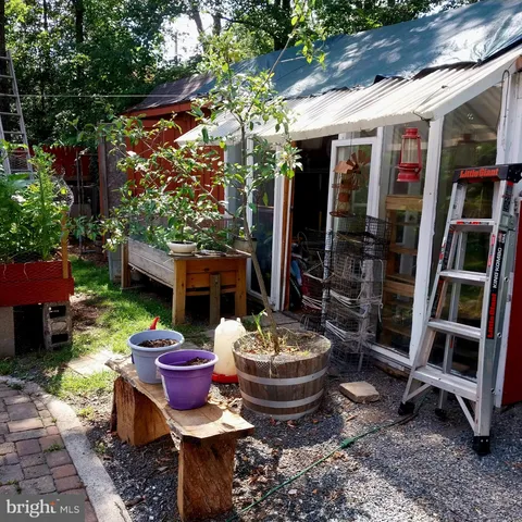 a view of a patio with table and chairs potted plants and wooden fence