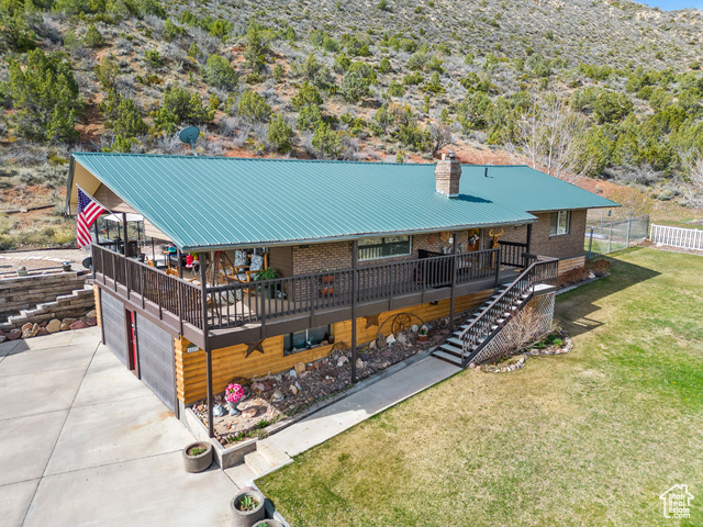6407 North Dry Frk Cyn Road West Vernal, UT 84078 - Photo 2 of 48 View of front of house with stairs, a chimney, concrete driveway, a wooden deck, and brick siding