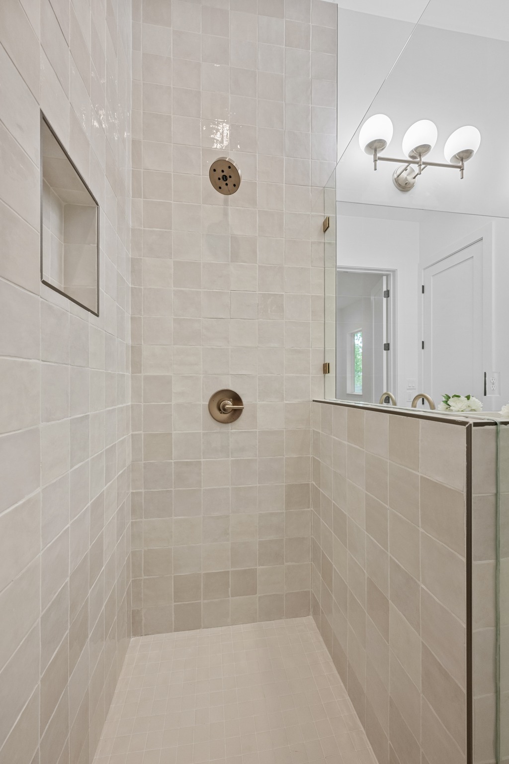 3614 Abbate Circle, Unit A Austin, TX 78721 - Photo 16 of 29 Spacious walk-in shower with light-toned square tile, a built-in shower niche, and bronze fixtures