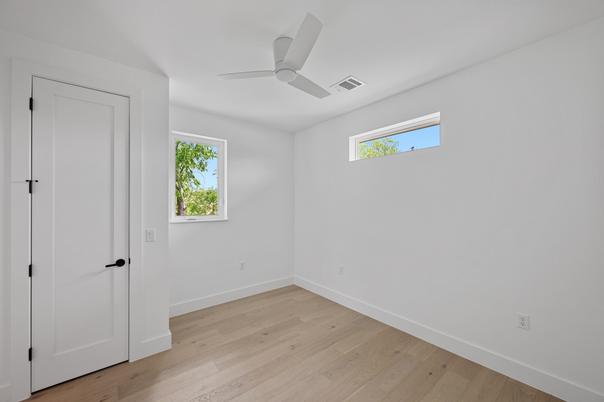 3614 Abbate Circle, Unit A Austin, TX 78721 - Photo 21 of 29 This room features light-toned hardwood flooring, white walls, and a modern ceiling fan