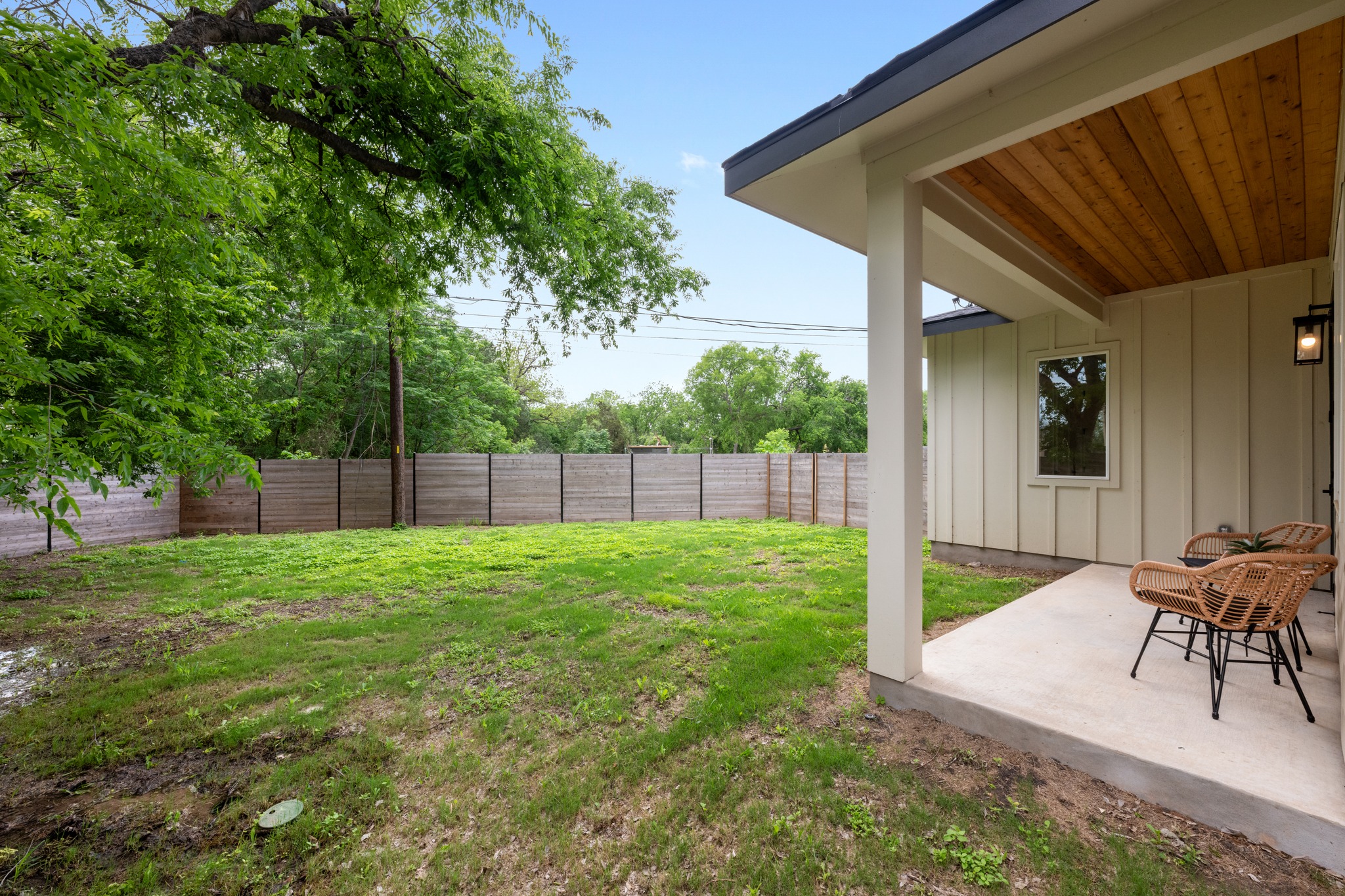 3614 Abbate Circle, Unit A Austin, TX 78721 - Photo 27 of 29 The property features a spacious lawn area, a covered patio with a wood-paneled ceiling, and a wooden fence