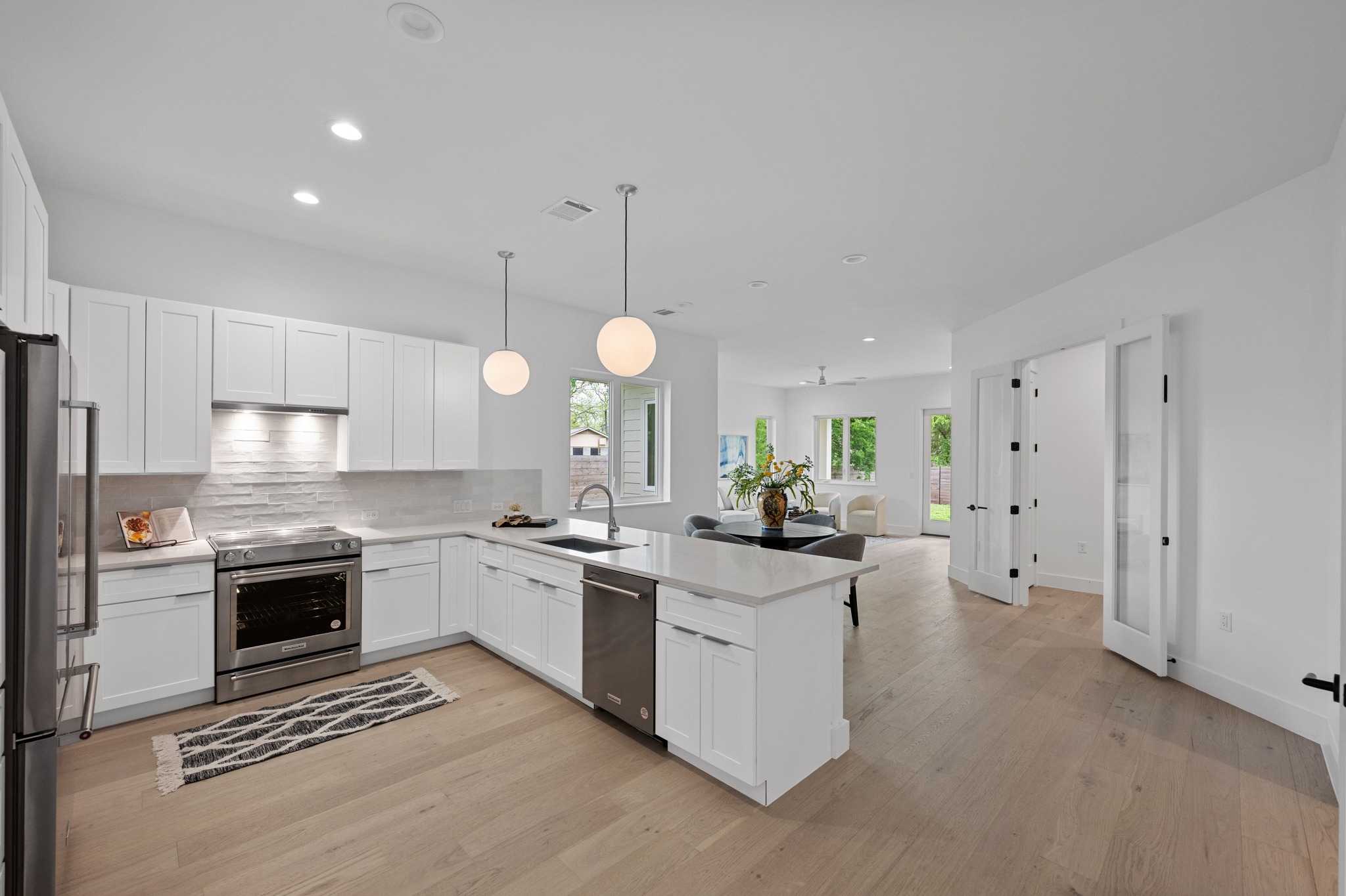 3614 Abbate Circle, Unit A Austin, TX 78721 - Photo 7 of 29 The kitchen features white cabinetry, a light-colored countertop, and a stainless steel range and dishwasher