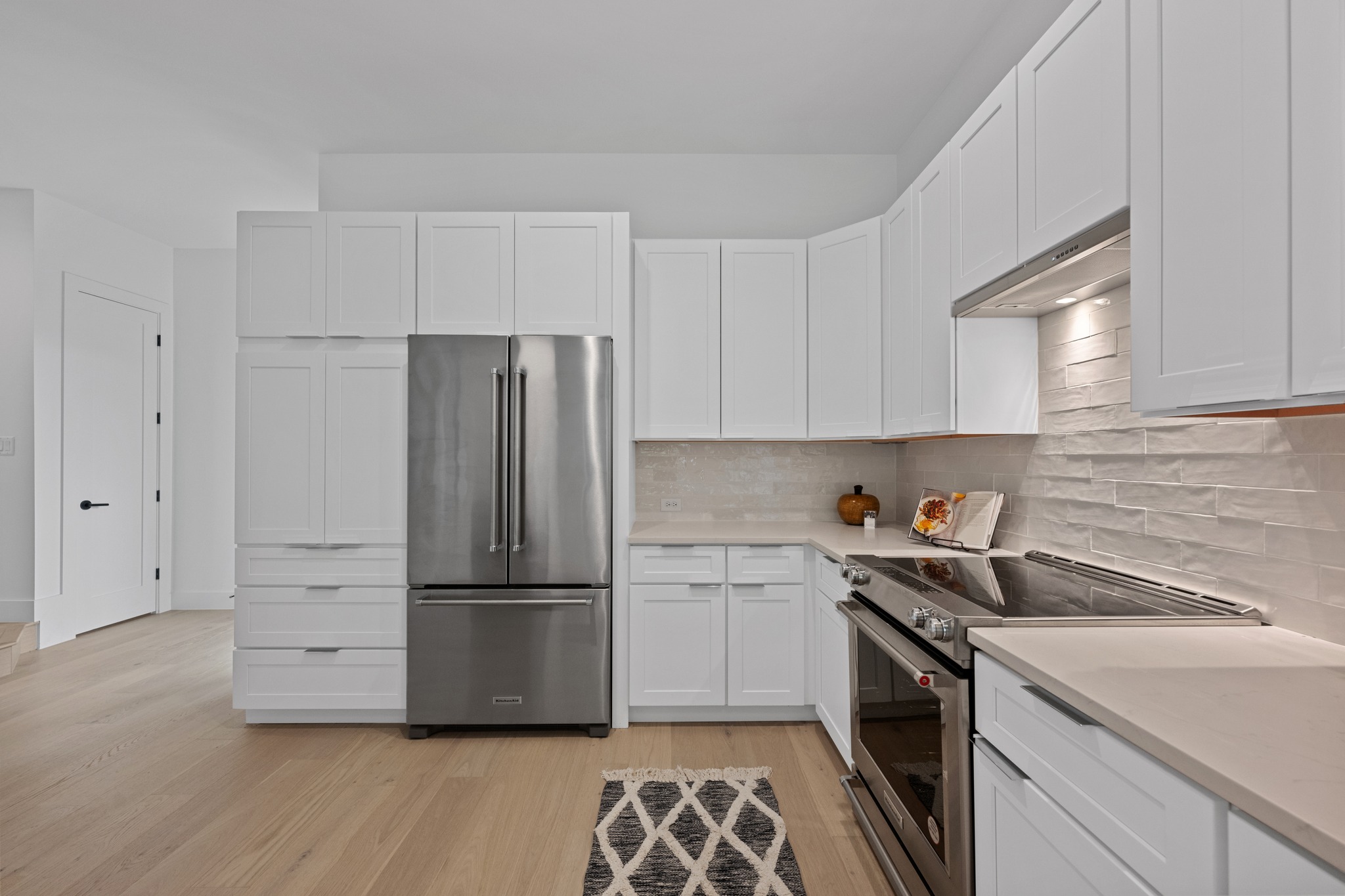 3614 Abbate Circle, Unit A Austin, TX 78721 - Photo 9 of 29 The kitchen features white cabinetry, light-colored countertops, and a full suite of stainless steel appliances