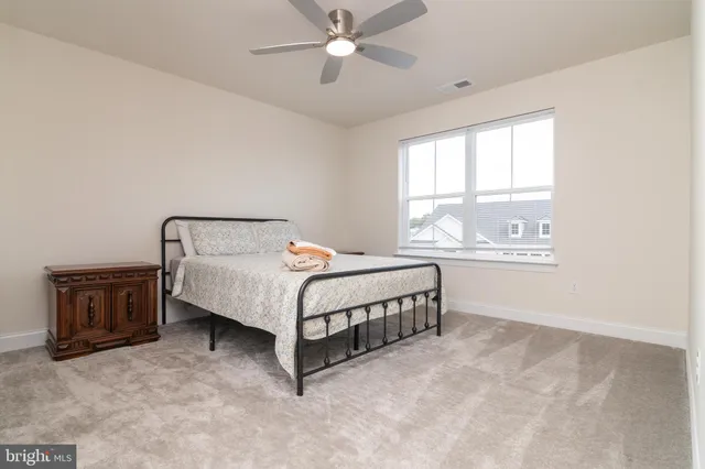 a bedroom with a bed and a ceiling fan