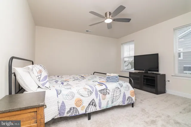 a bedroom with a bed and a ceiling fan
