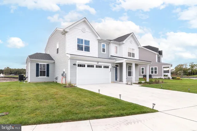 a front view of a house with a garden and yard