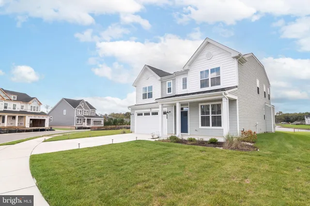 a view of a white house with a big yard and large trees