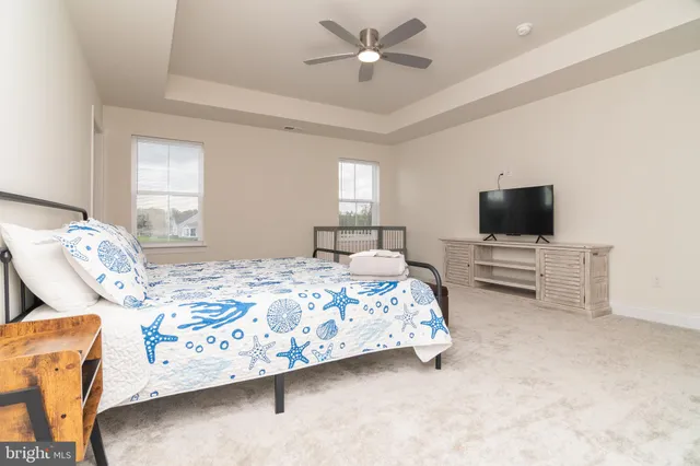 a bedroom with bed and flat tv screen on dresser