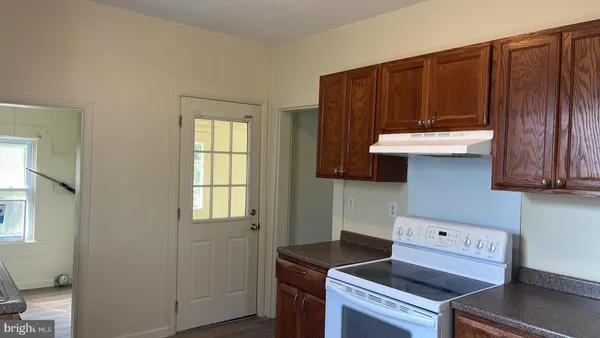 a kitchen with a sink a cabinets and wooden floor