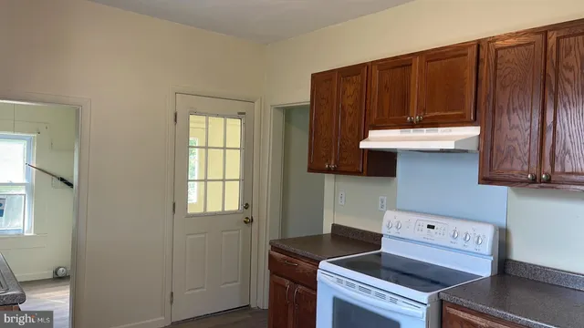 a kitchen with a sink a cabinets and wooden floor