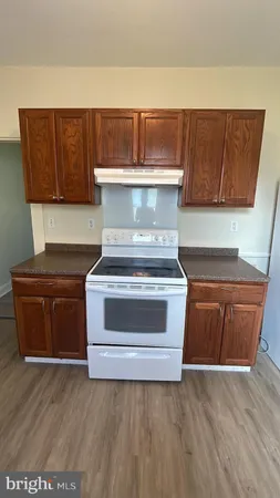 a white toilet sitting next to a wooden cabinet