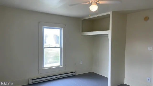 an empty room with windows and closet