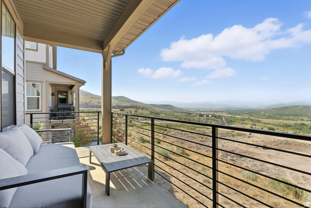 6039 North Westridge Road Heber City, UT 84032 - Photo 8 of 22 Covered outdoor patio with concrete flooring, featuring a black metal horizontal railing