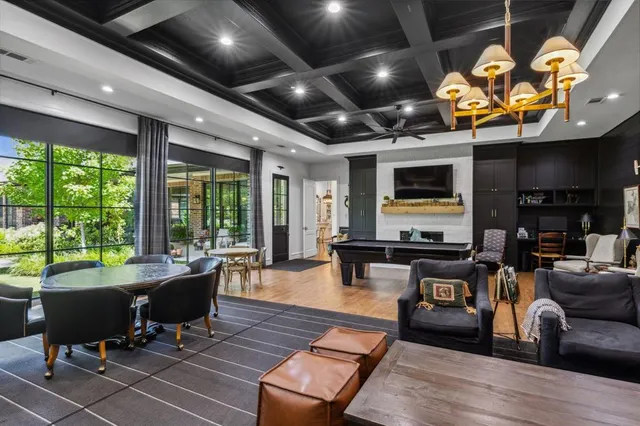 a living room with furniture pool table and a wooden floor