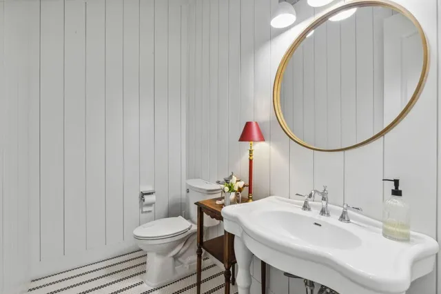 a bathroom with a double vanity sink mirror and toilet