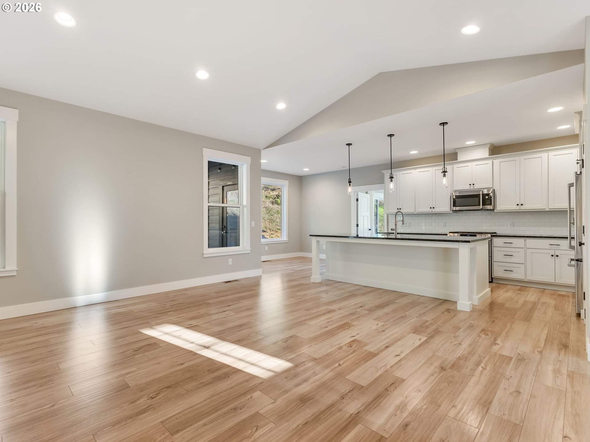 37027 Danner Ridge Lane Astoria, OR 97103 - Photo 14 of 46 a large kitchen with granite countertop a stove top oven a sink dishwasher and a refrigerator with wooden floor