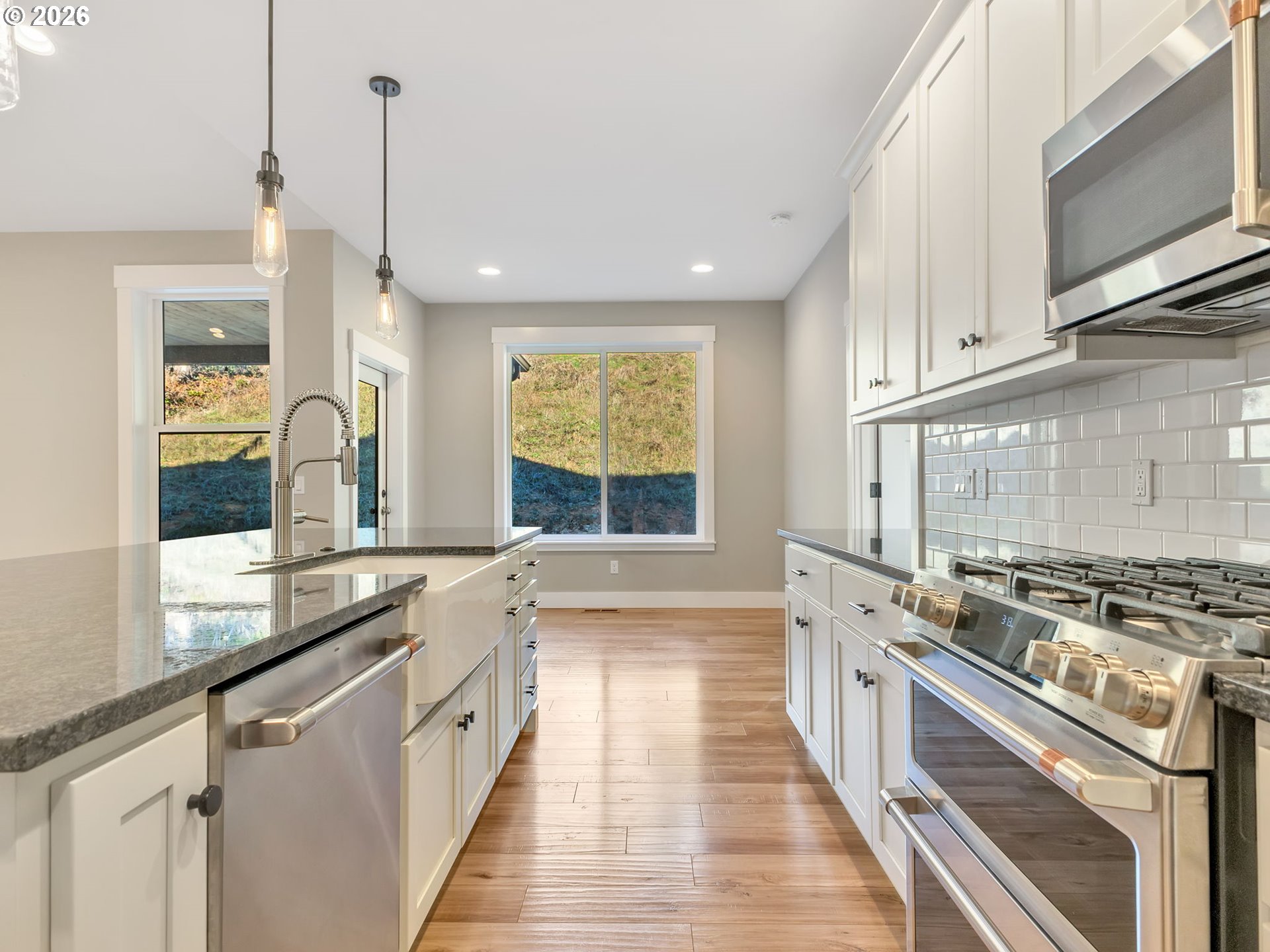 37027 Danner Ridge Lane Astoria, OR 97103 - Photo 17 of 46 a kitchen with stainless steel appliances white cabinets a stove a sink a window and wooden floor