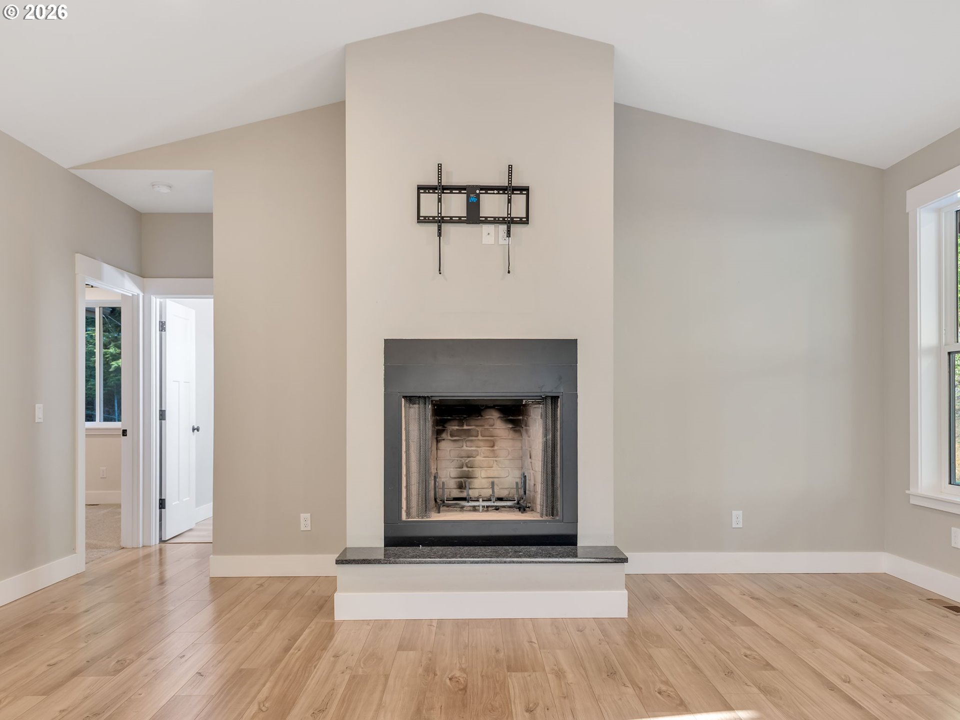 37027 Danner Ridge Lane Astoria, OR 97103 - Photo 9 of 46 an empty room with a fireplace and wooden floor