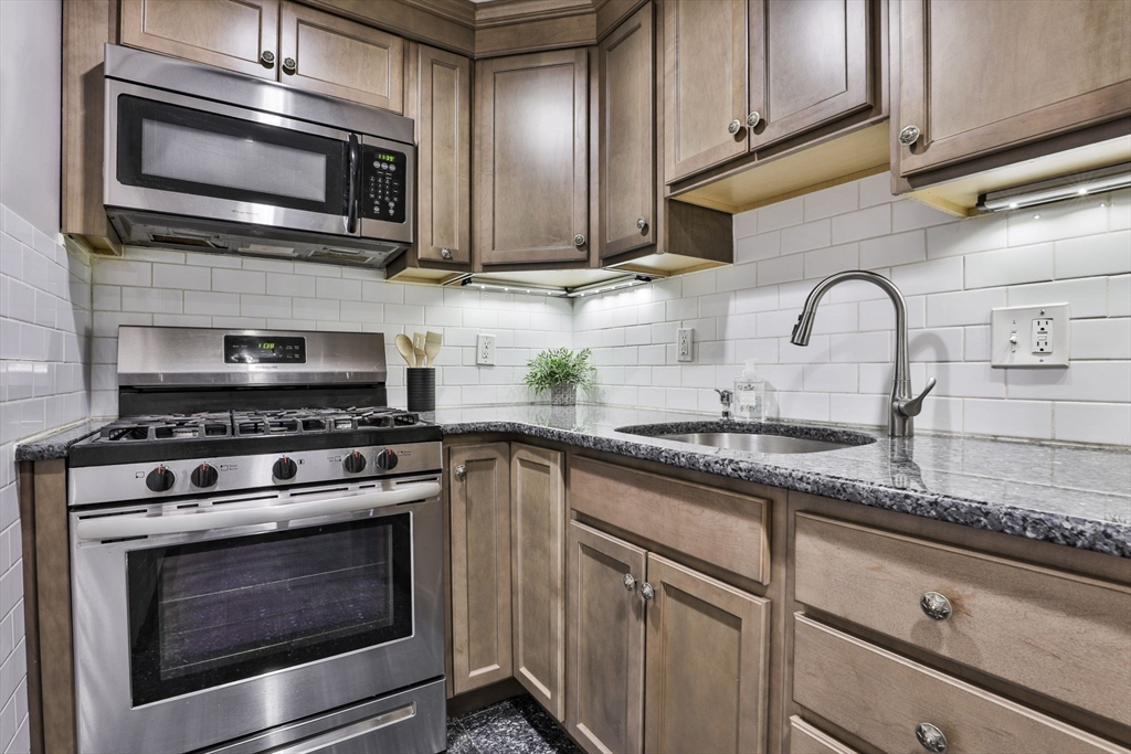 5 Karen Circle, Unit 4 Billerica, MA 01821 - Photo 6 of 12 a kitchen with granite countertop wooden cabinets stainless steel appliances and a sink