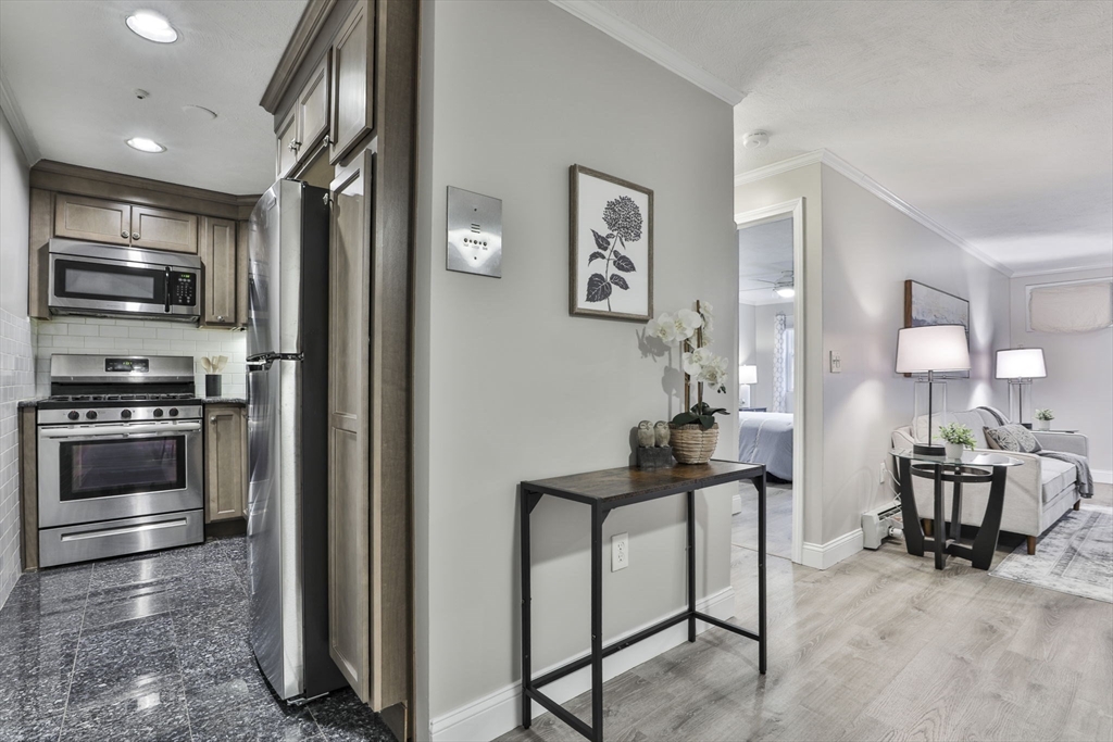 5 Karen Circle, Unit 4 Billerica, MA 01821 - Photo 7 of 12 a kitchen with stainless steel appliances kitchen island granite countertop a refrigerator and a stove top oven