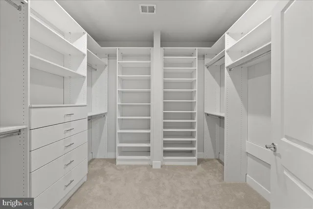 a view of walk in closet with empty racks