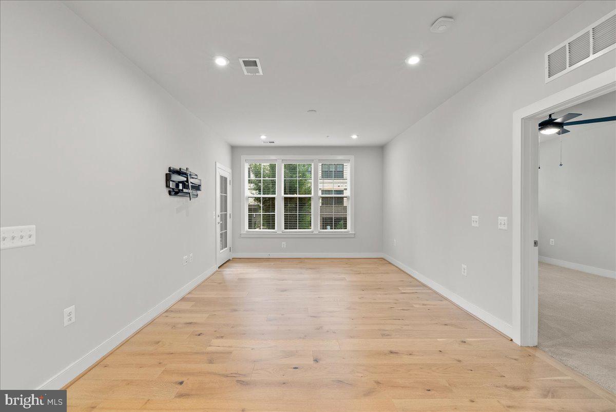 2320 Field Point Road, Unit 103 Herndon, VA 20171 - Photo 16 of 22 a view of an empty room with wooden floor and a window