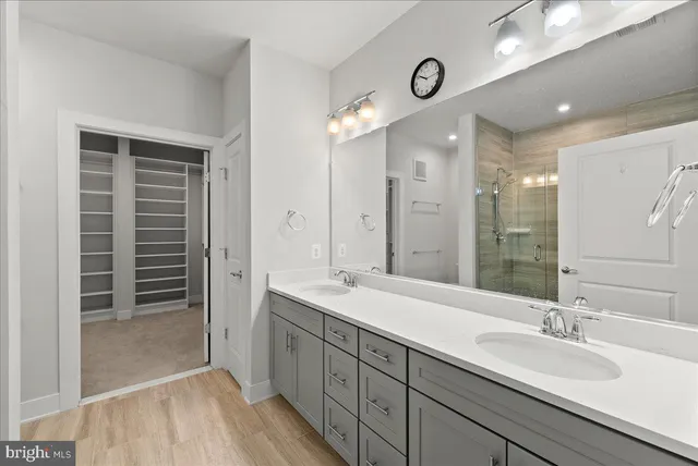 a bathroom with double vanity sinks and a shower