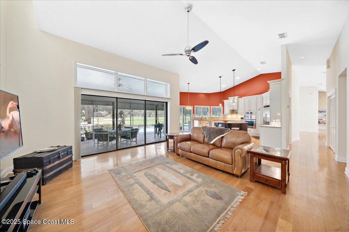 649 Spring Lake Drive Melbourne, FL 32940 - Photo 11 of 47 a living room with furniture a floor to ceiling window and a flat screen tv