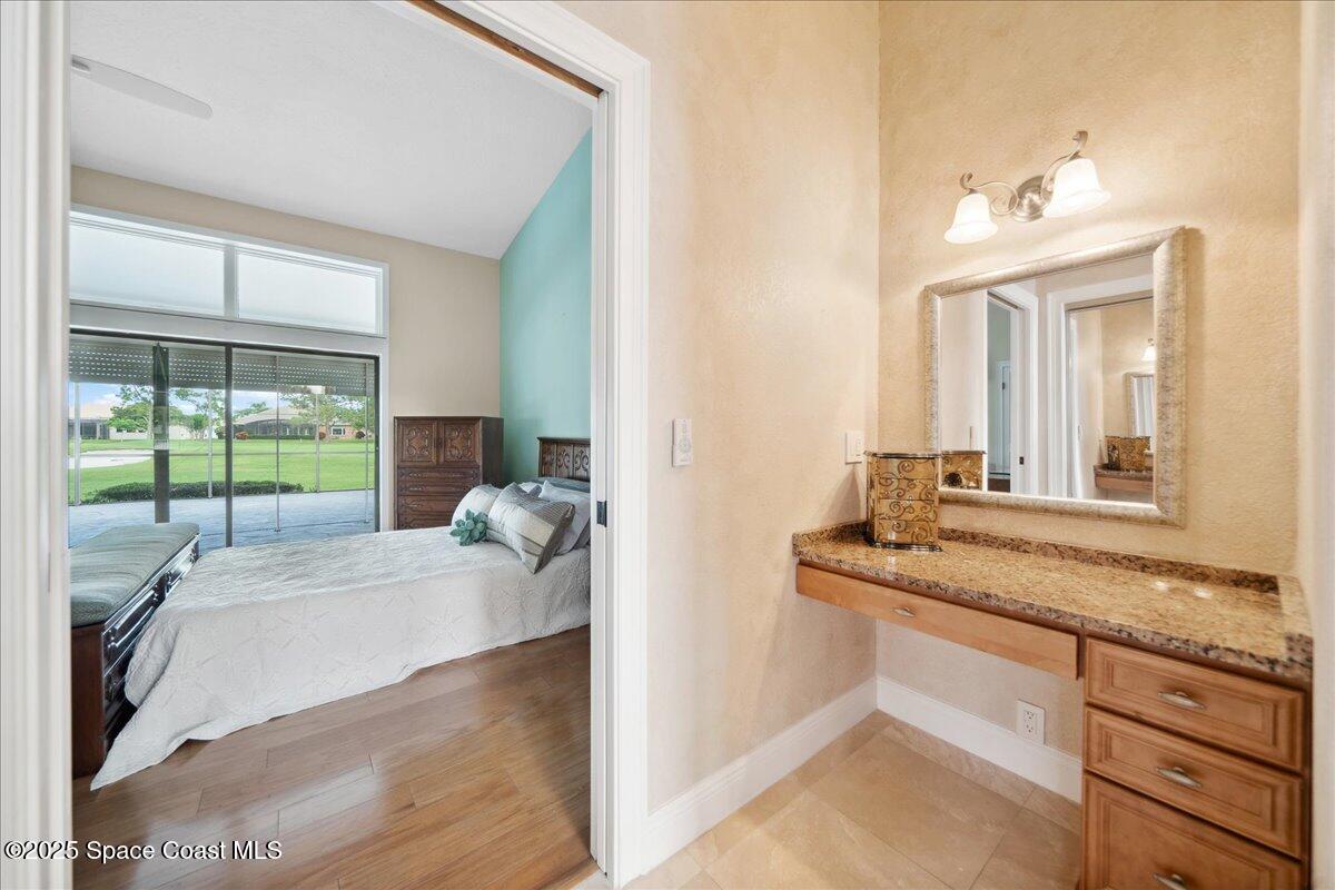 649 Spring Lake Drive Melbourne, FL 32940 - Photo 23 of 47 a en suite bathroom with a granite countertop sink and a mirror