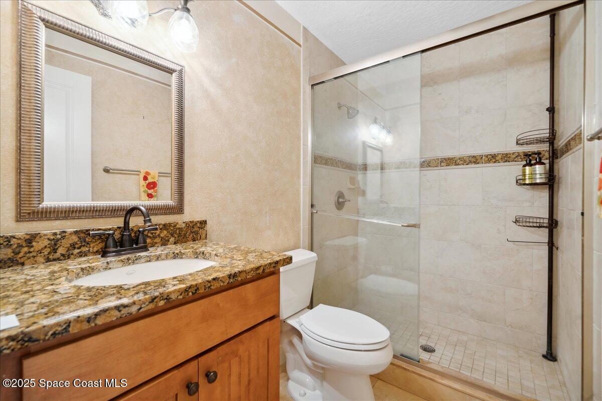 649 Spring Lake Drive Melbourne, FL 32940 - Photo 24 of 47 a bathroom with a granite countertop sink toilet and shower