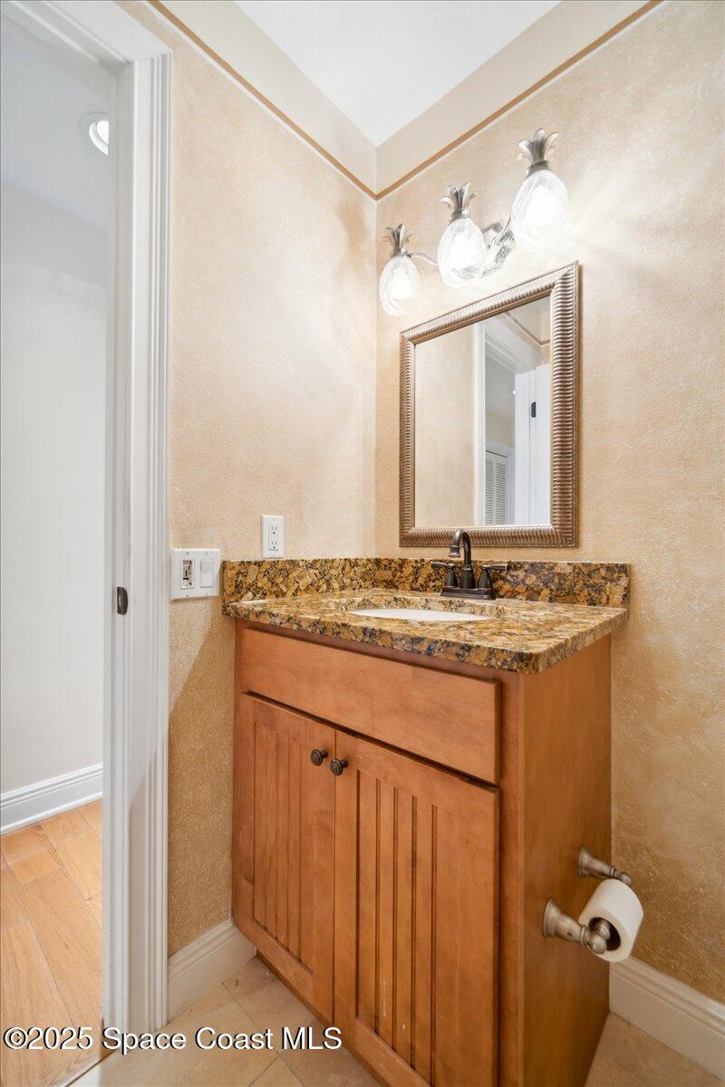 649 Spring Lake Drive Melbourne, FL 32940 - Photo 25 of 47 a bathroom with a granite countertop sink and a mirror