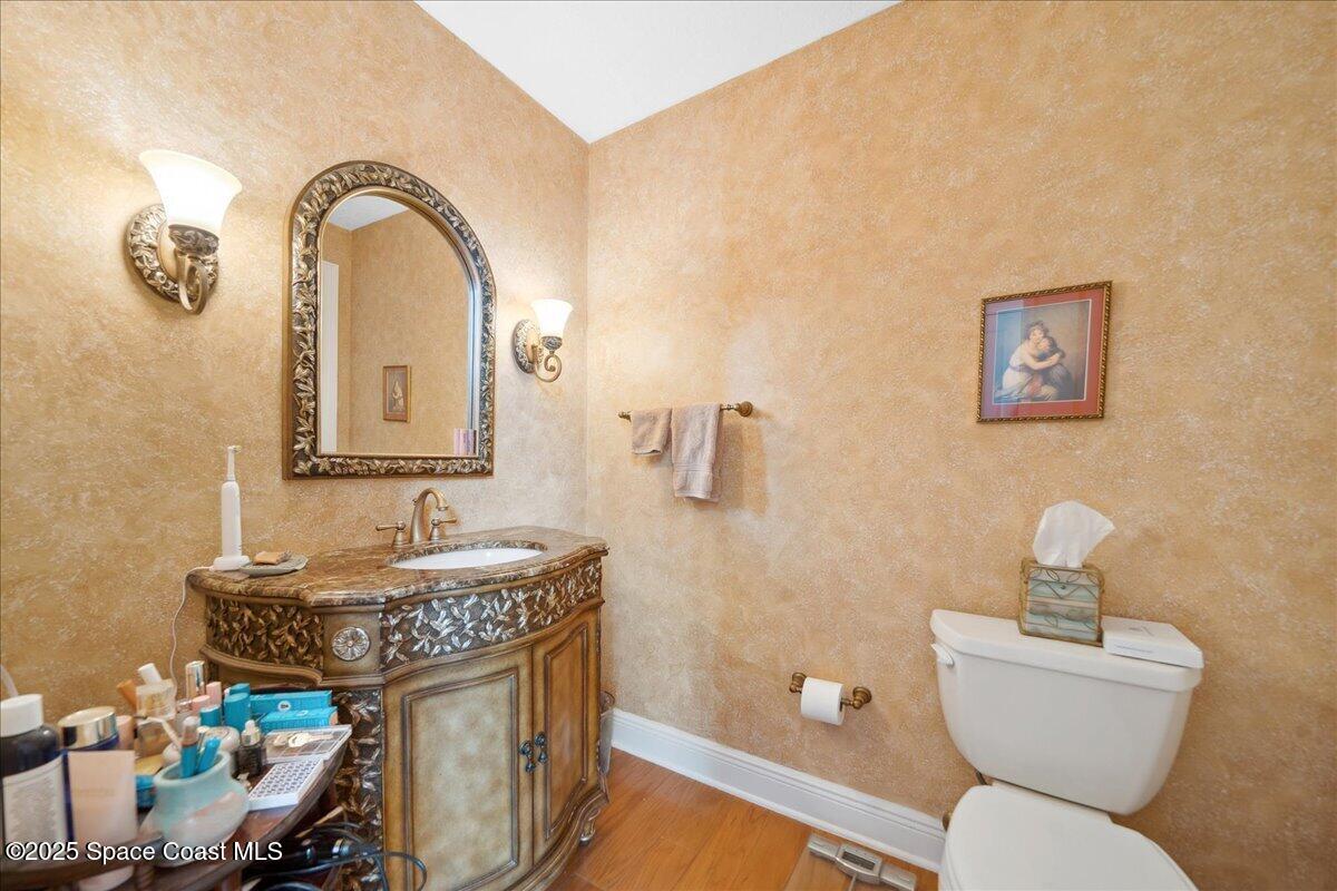 649 Spring Lake Drive Melbourne, FL 32940 - Photo 26 of 47 a bathroom with a toilet sink and mirror