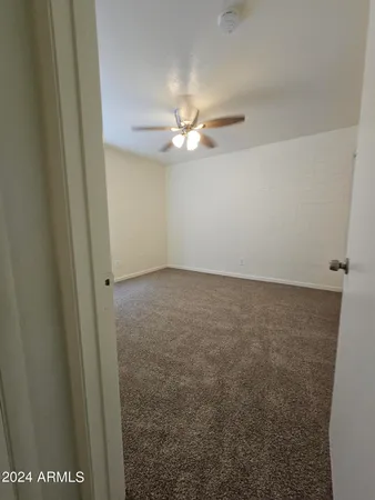 en empty room with windows and fan